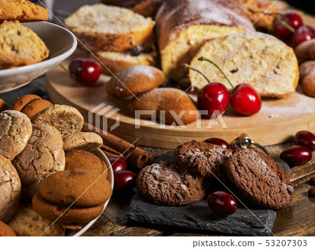 Sand chocolate cookies heart shape and rolled cake with cherry 53207303