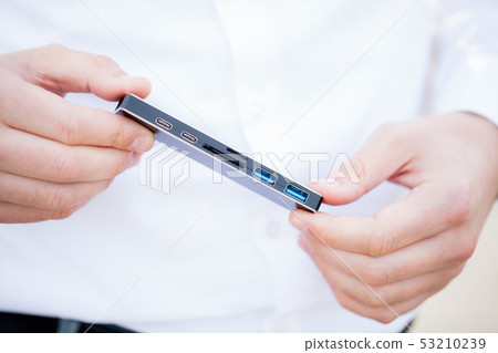 Man holding mini adapter for laptops and flash memory Man holding mini adapter for laptops and flash memory 53210239