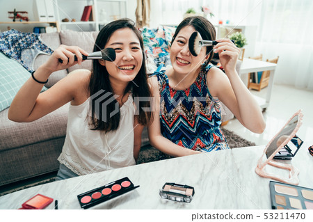 girls face camera having fun with cosmetic brush 53211470