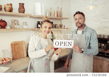 Owners of family coffee shop greeting their visitors. 53216388