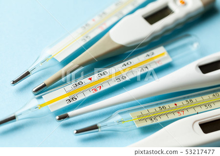Medical thermometers glass and electronic on blue background Medical thermometers glass and electronic on blue background 53217477