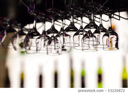 Glasses for fortified wine hang over a bar Glasses for fortified wine hang over a bar 53220872