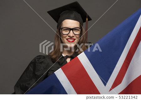 Charming female student smiling in eyeglasses wearing black mantle 53221342