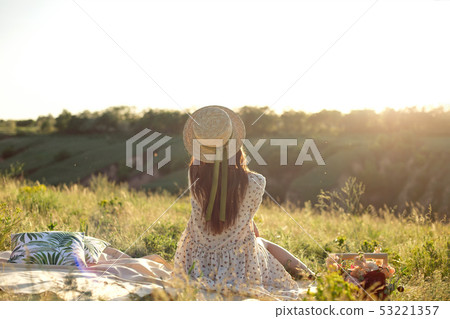 Happy woman lifestyle, beautiful relaxed girl in a straw hat on the nature from the back on picnic - 53221357