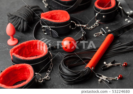 Set of erotic toys for BDSM. The game of sexual slavery with handcuffs, whip, gag and leather straps Set of erotic toys for BDSM. The game of sexual slavery with handcuffs, whip, gag and leather straps 53224680