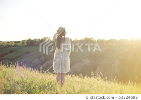 Happy woman with open arms stay on the peak of the mountain cliff edge under sunset light sky Happy woman with open arms stay on the peak of the mountain cliff edge under sunset light sky 53224689