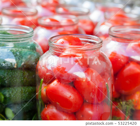 Pickling (canning) tomatoes and cucumbers. 53225420