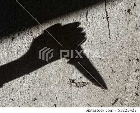Shadow of the hand holding a knife Shadow of the hand holding a knife 53225422