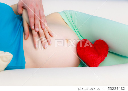 Couple expecting baby, their hands touching Couple expecting baby, their hands touching 53225482