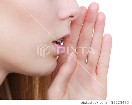 Young blonde woman whispering with hand near mouth Young blonde woman whispering with hand near mouth 53225483