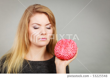 Woman thinking and holding fake brain 53225548