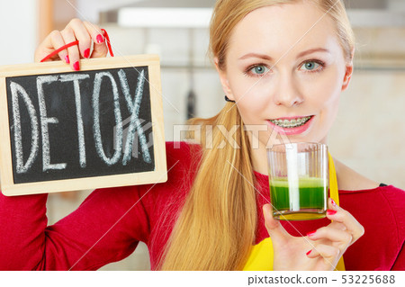 Woman holding vegetable juice and detox sign Woman holding vegetable juice and detox sign 53225688