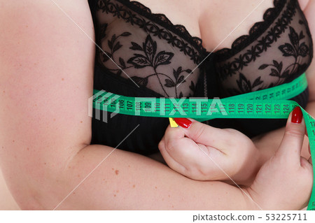 Woman measuring her chest breasts bust size 53225711