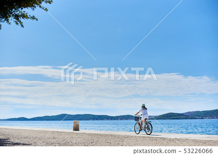 Young woman riding city bicycle near sea 53226066