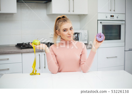 Diet. The concept of healthy and unhealthy nutrition. The model plus size makes a choice in favor of 53226138