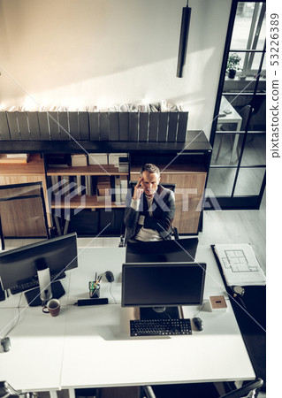 Busy interior designer sitting in front of computer feeling thoughtful Busy interior designer sitting in front of computer feeling thoughtful 53226389