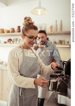 Smiling barista frothing fresh milk for cappuccino. Smiling barista frothing fresh milk for cappuccino. 53227349