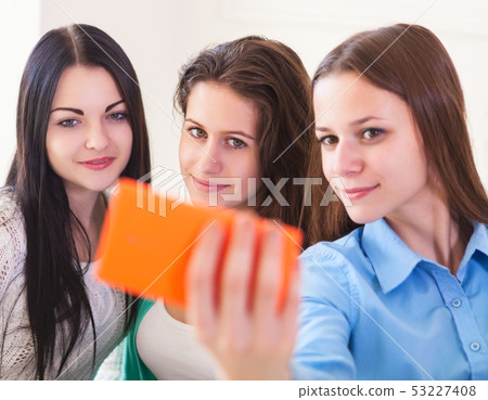 Three smiling teenage girls taking selfie with Three smiling teenage girls taking selfie with 53227408