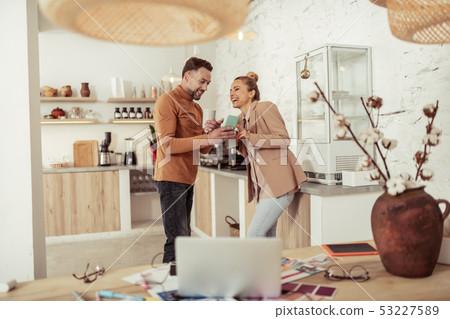 Two colleagues drinking coffee and laughing together. Two colleagues drinking coffee and laughing together. 53227589