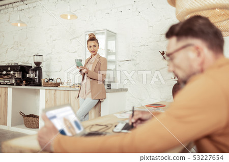 Beautiful woman standing near coffee machine looking at her boss. Beautiful woman standing near coffee machine looking at her boss. 53227654