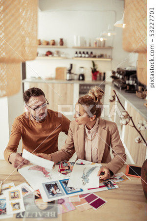 Designers discussing sketches for their new collection. 53227701