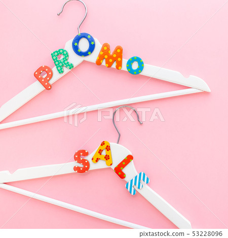 White hangers with sale text on pink background 53228096