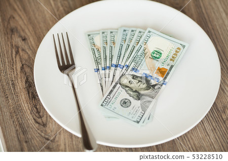 Money lying on the plate with fork. Dollars photo. Greedy corruption concept. Bribe idea 53228510
