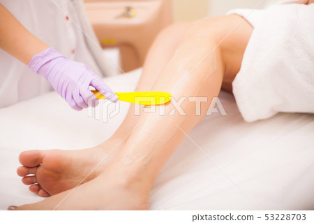 Skin Care. Hair removal on the legs, laser procedure at clinic. Beautician removes hair on beautiful 53228703