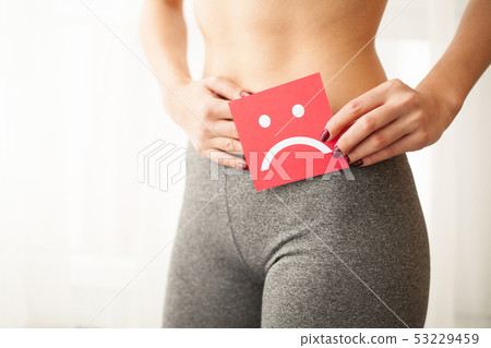 Vaginal or urinary infection and problems concept. Young woman holds paper with sad smile above 53229459