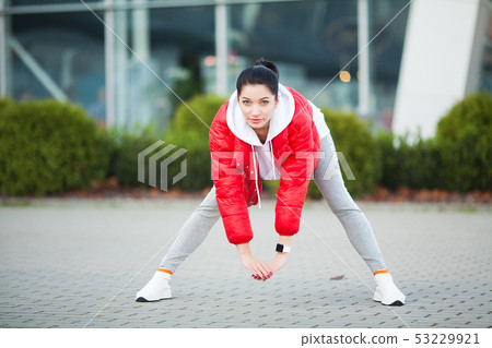 Fitness girl. Young sports woman stretching in the modern city. Healthy lifestyle in the big city Fitness girl. Young sports woman stretching in the modern city. Healthy lifestyle in the big city 53229921