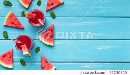Watermelon juice and slices on blue wooden background 53230829