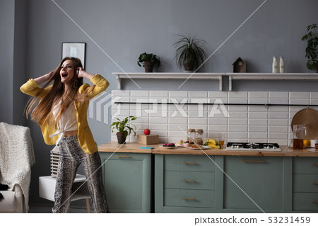Stylish woman in yellow jacket and blue headphones Stylish woman in yellow jacket and blue headphones 53231459