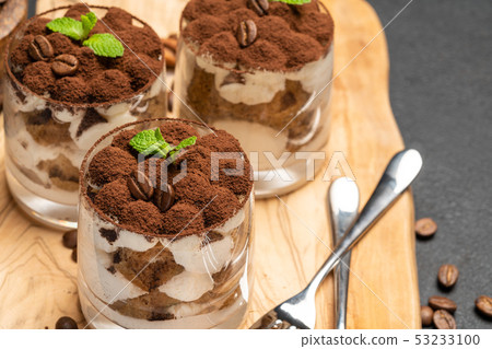 Classic tiramisu dessert in a glass on dark concrete background 53233100