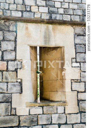A window for bows and arrows opened on the castle wall of Windsor Castle and trees seen from a gap A window for bows and arrows opened on the castle wall of Windsor Castle and trees seen from a gap 53233776