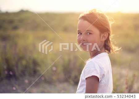 Happy little girl smile at camera with sunset Happy little girl smile at camera with sunset 53234043