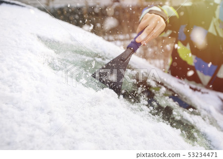 Scraping ice from the car window Scraping ice from the car window 53234471