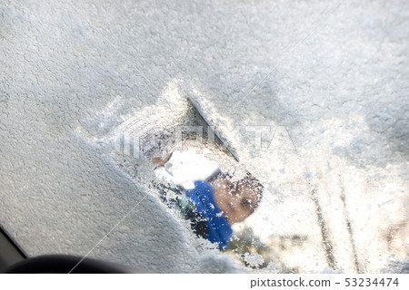 winter driving - scraping ice from a windshield winter driving - scraping ice from a windshield 53234474