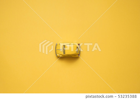 Yellow retro toy car on yellow background. Yellow retro toy car on yellow background. 53235388