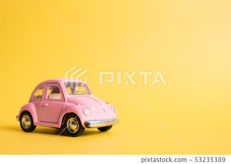 Pink retro toy car on yellow background. Pink retro toy car on yellow background. 53235389