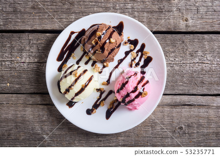 Ice cream with walnuts and chocolate topping Ice cream with walnuts and chocolate topping 53235771