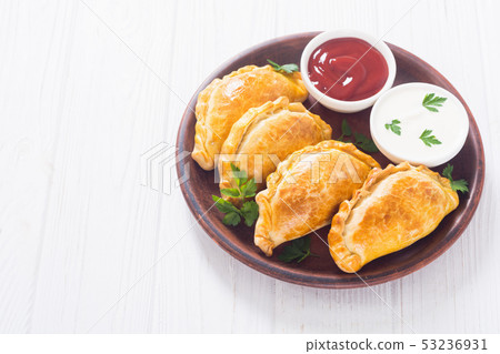 Latin American baked beef empanadas with sauce 53236931
