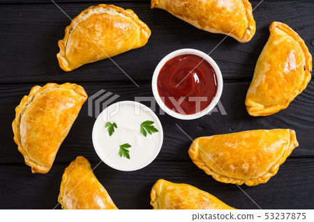 Latin American baked beef empanadas with sauce 53237875