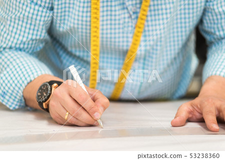 Tailor hands mark drawing on craft paper for making patterns. Tailor hands mark drawing on craft paper for making patterns. 53238360