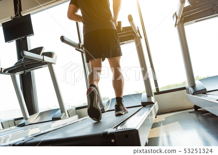 Legs of sportsman running on treadmill in fitness 53251324