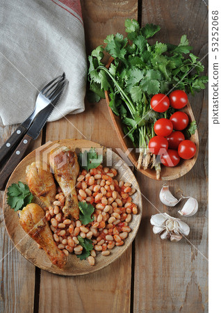 fried chicken legs with beans and tomatoes on a fried chicken legs with beans and tomatoes on a 53252068