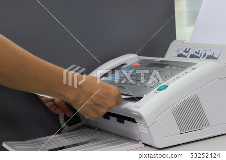 Hand man are using a fax machine in the office Hand man are using a fax machine in the office 53252424