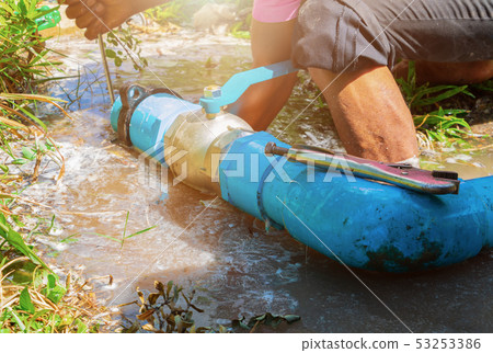 broken pipe in hole with water motion at roadside 53253386