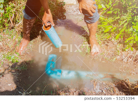 broken pipe in hole with water motion at roadside 53253394