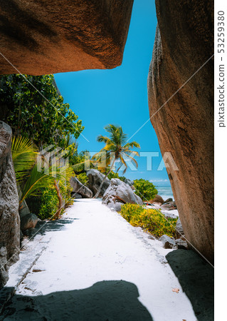 Walking path through giant bizarre granite rock boulders at the famous Anse Source d'Argent beach on 53259380