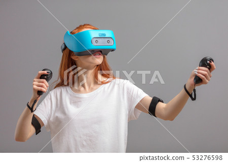 Redhead girl using VR glasses isolated over white. Virtual reality experience 53276598